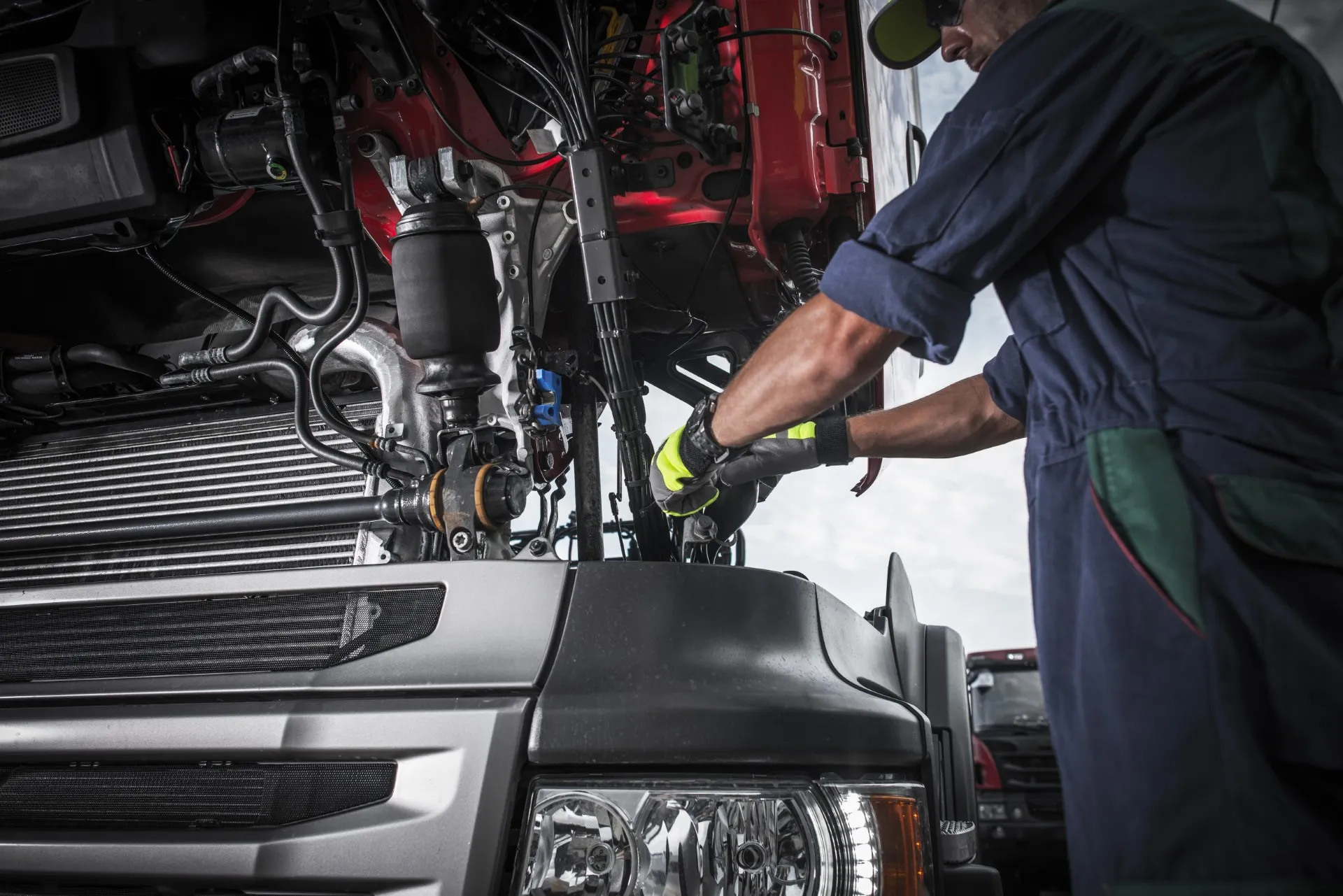 Mechanic repairs truck engine in a vehicle repair shop